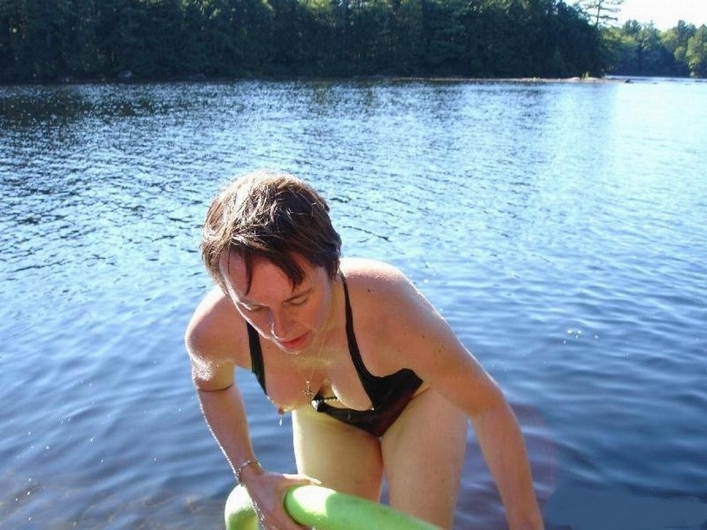 Девушка надевает купальник на пляже оголив грудь фото