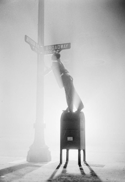 A man uses a mailbox to read a road sign on a foggy night - Photo, Los Angeles, Fog, Night