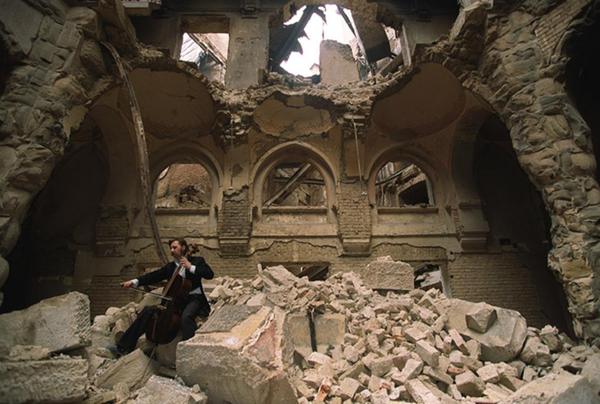 Cellist Vedran Smajlovic plays in the ruins of the bombed-out National Library. - The photo, Historical photo, Sarajevo