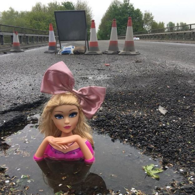 'Queen of the Pit': British man covers holes in the road with doll heads - Road, England, Potholes, Creative, Creative solution