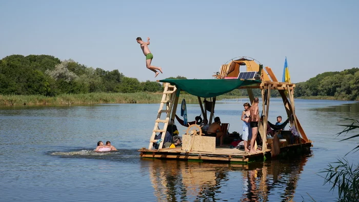 Туристы сплавляются на плоту по реке на рисунке