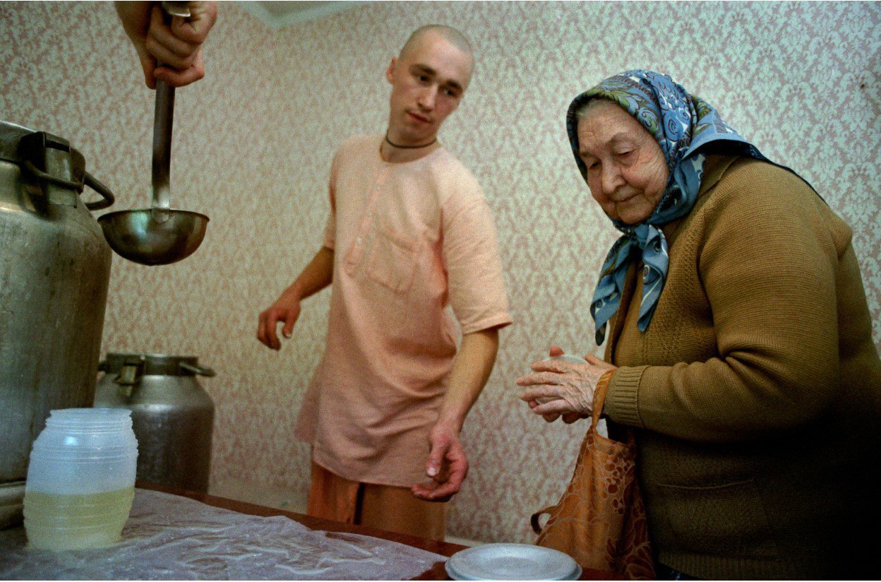 A pensioner receives food in exchange for a portion of chants in the Moscow branch of the Hara Krishna sect, 1993. - Photo, Retirees, 90th, Hare Krishna